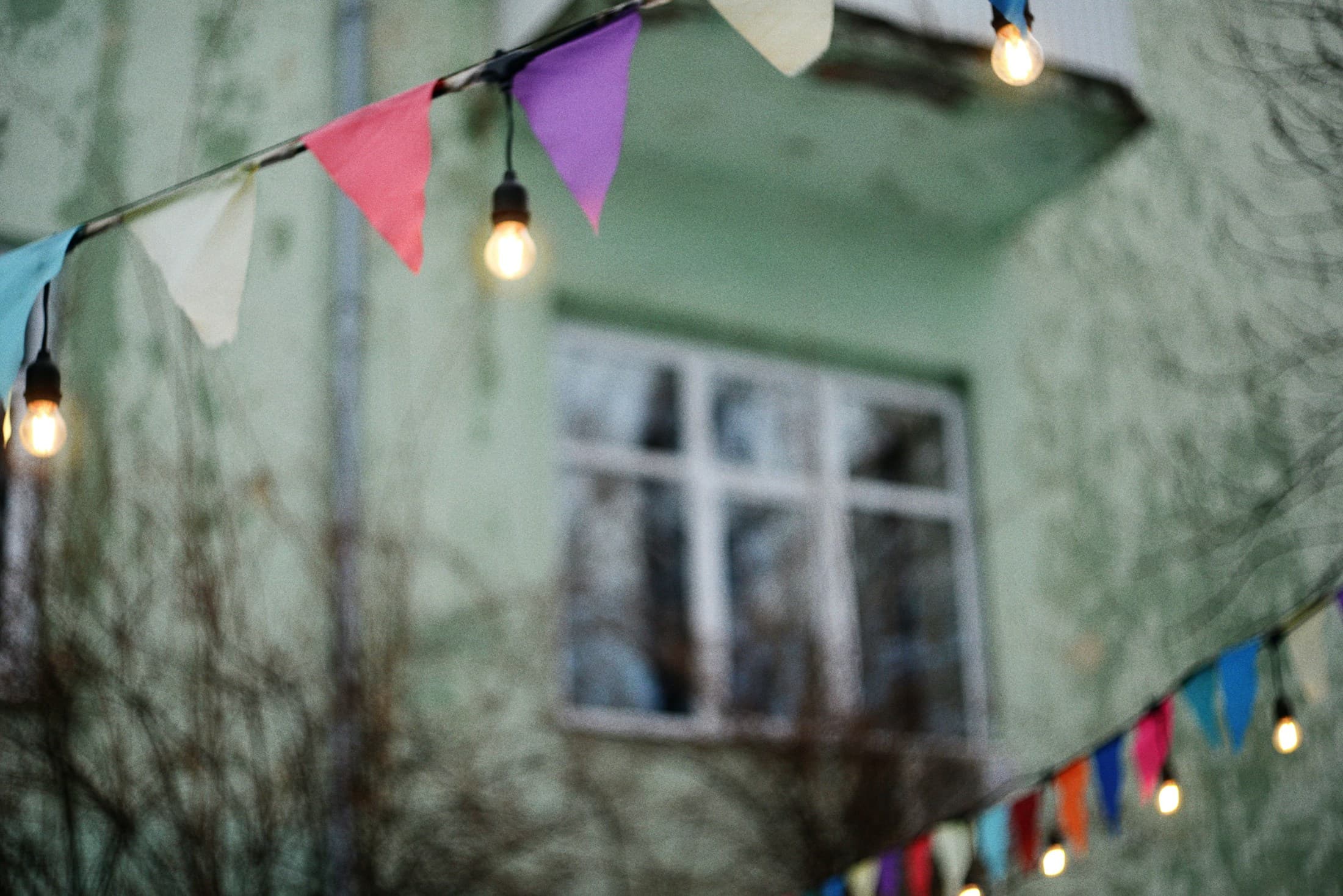 Warm string lights over an outdoor evening gathering